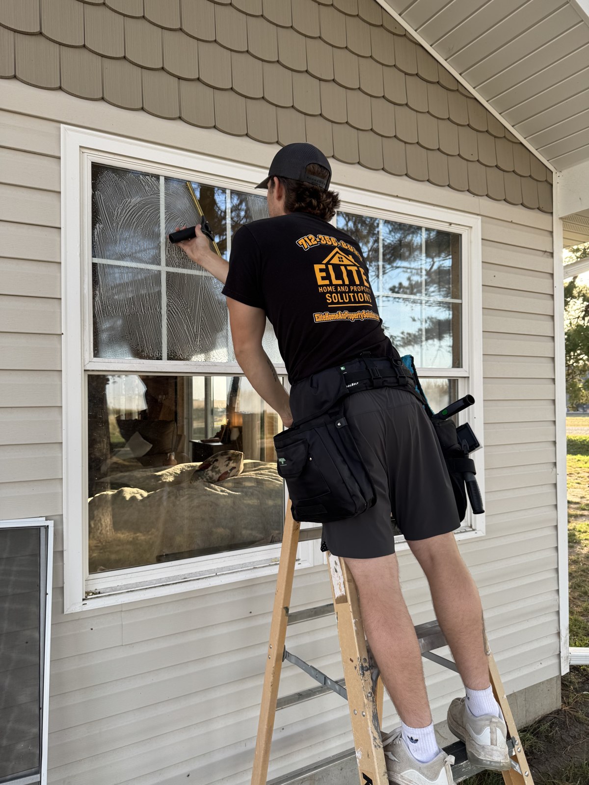 Elite cleaning windows at a local home