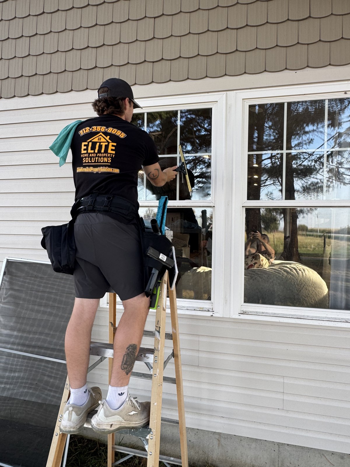 Elite team member carefully cleaning a residential window